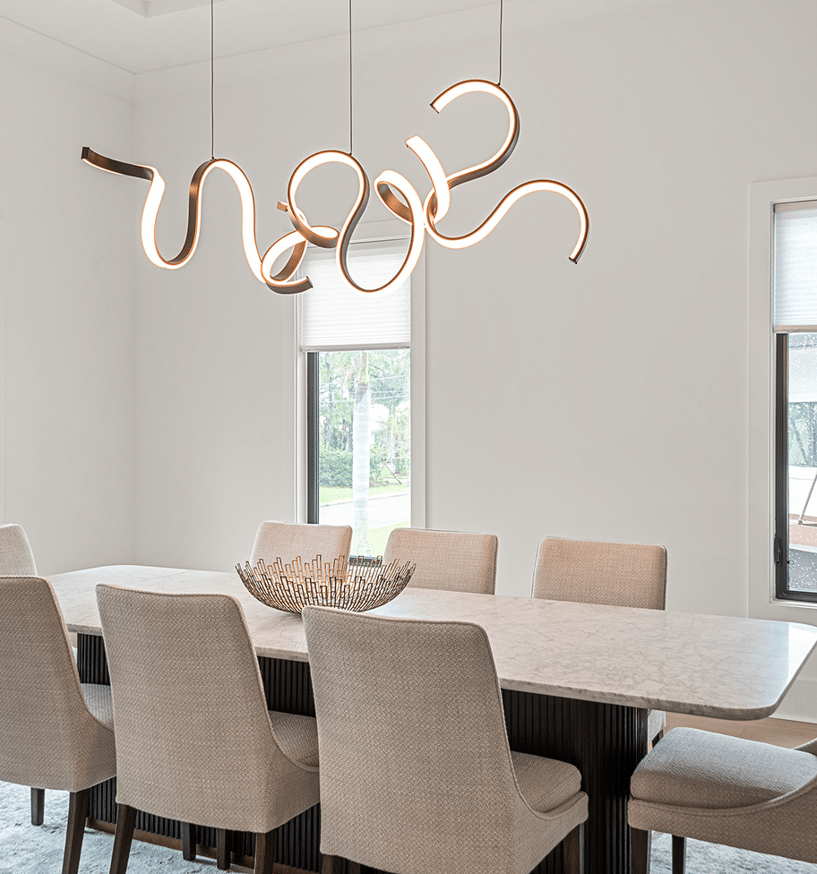 Dining table under a ribbon-shaped chandelier
