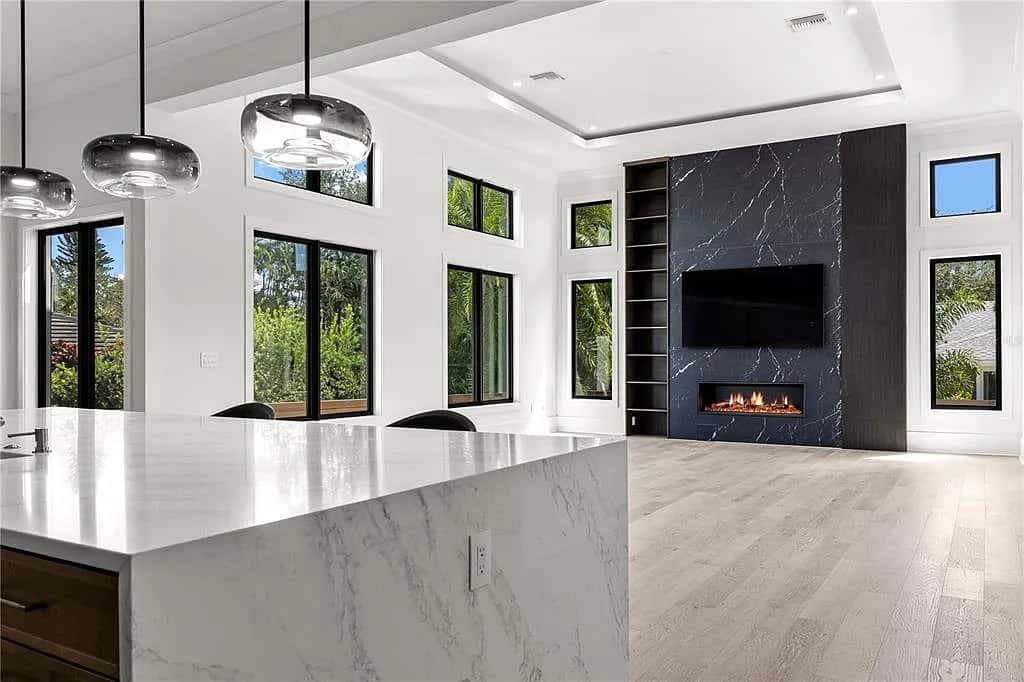 Open great room with island and fireplace in a Signature Bay Homes luxury home